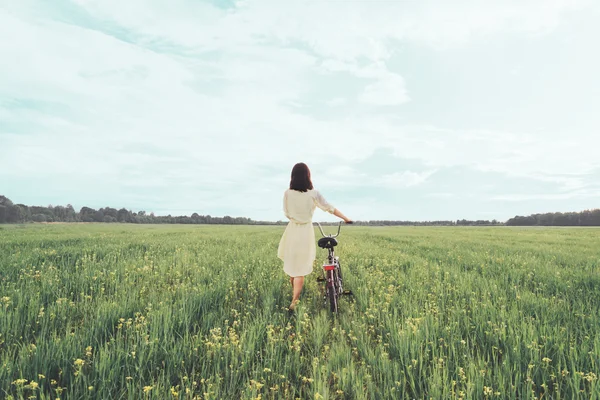 Girl walking with bicycle in summer — Stock Photo, Image