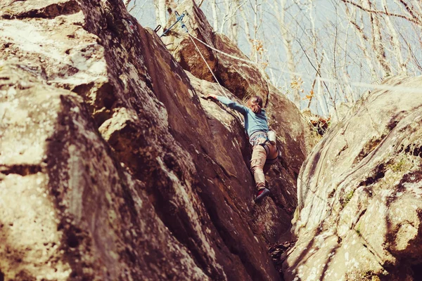 young woman climbing rock