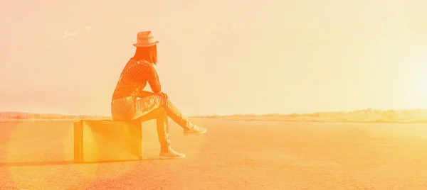 Voyageur assis sur une valise au soleil jour — Photo