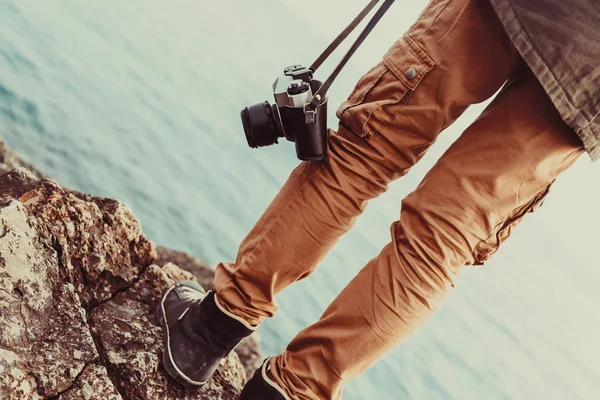 Viajero con cámara de pie en la costa — Foto de Stock