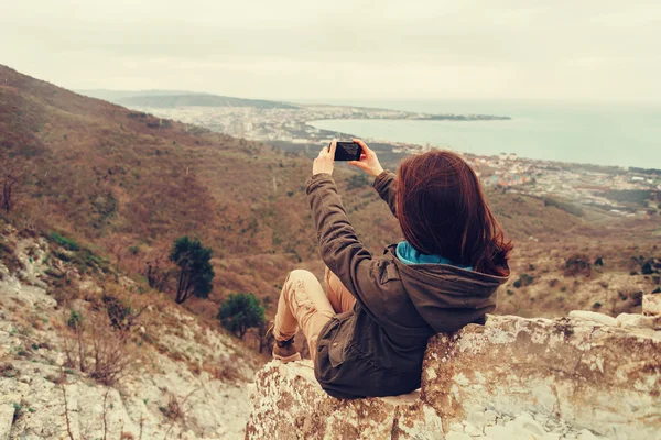 Flicka med fotograferar landskap med telefonen — Stockfoto