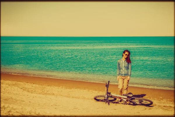 Dívka s kolo na letní beach — Stock fotografie