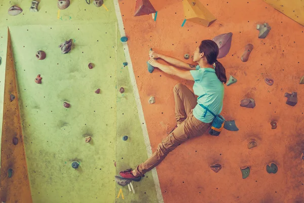 Mujer escalando roca artificial en el gimnasio —  Fotos de Stock