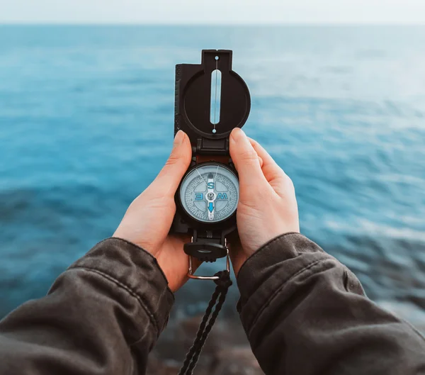 Touristen suchen Richtung mit Kompass an der Küste — Stockfoto