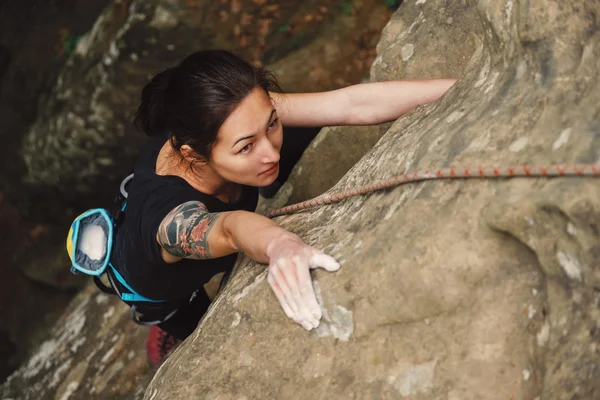 young woman climbing on rock