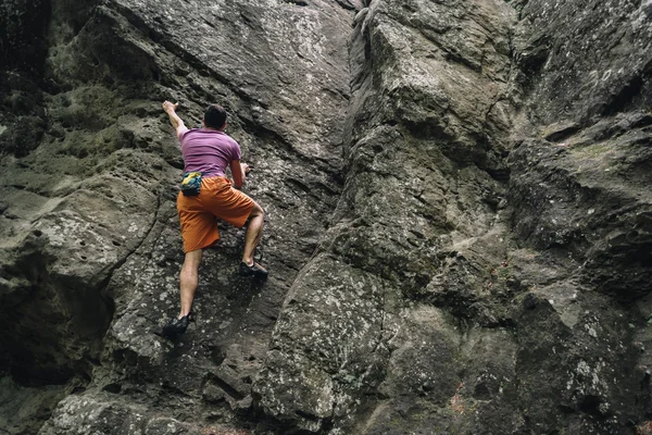 Jeune homme escalade sur rocher de pierre — Photo