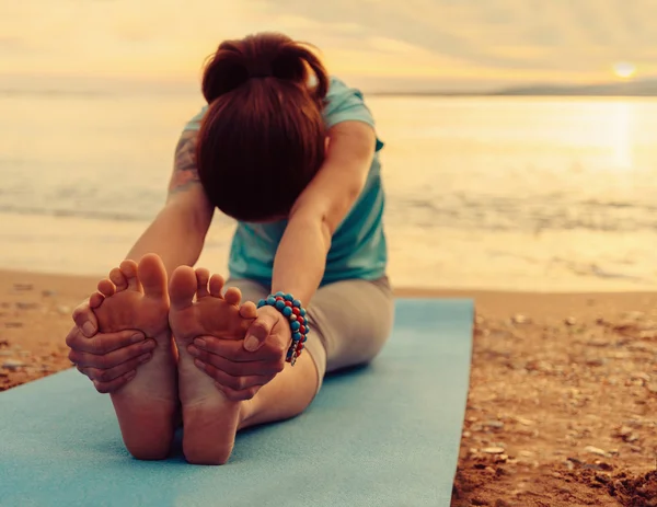 Kadın plajda yoga egzersizi yapıyor. — Stok fotoğraf