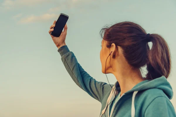 Sporty woman doing self-portrait with smartphone — Stock Photo, Image