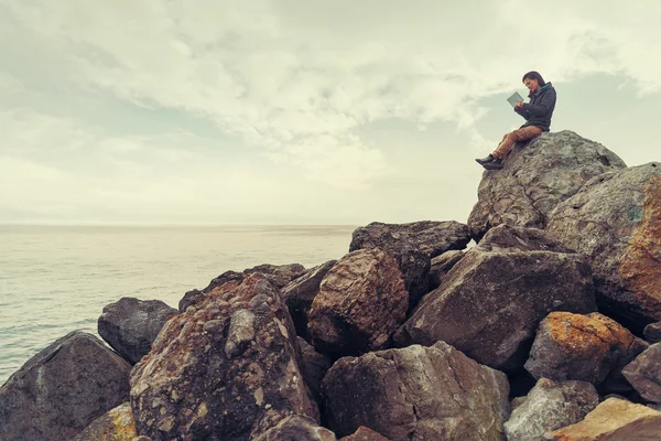 Traveler ung kvinna med digital tablet på sten coast nära havet — Stockfoto