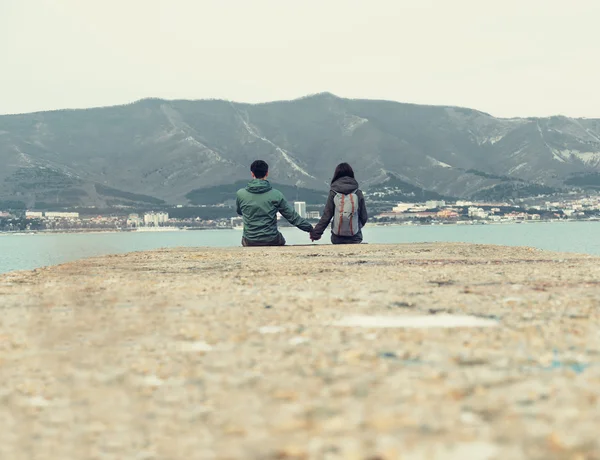 Loving couple sitting on pier