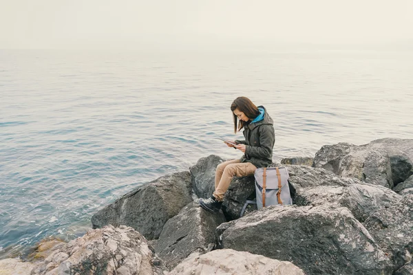Viajero trabajando en tableta digital en la costa — Foto de Stock
