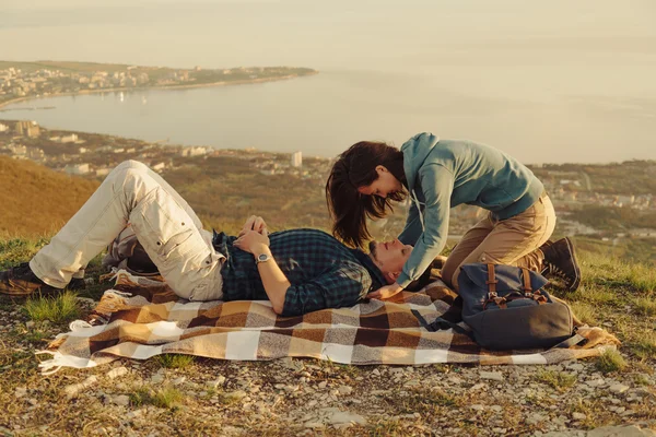 Loving couple resting on peak of mountain