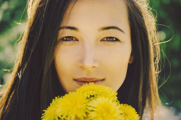 Woman with bouquet of dandelions — Stock Photo, Image