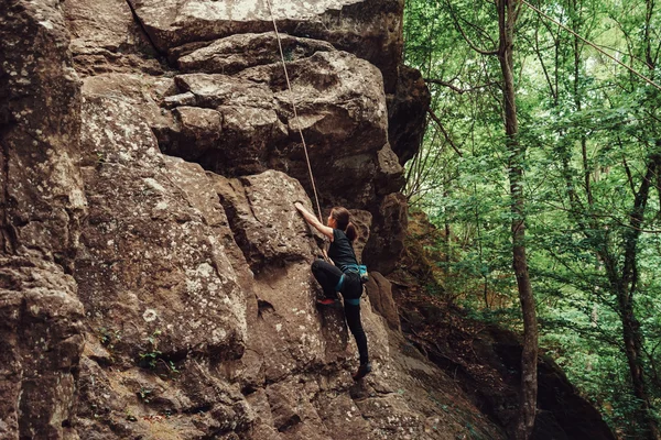 Sporty young woman climbing outdoor — Stok fotoğraf