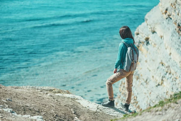 Traveler girl standing on coast — Stock Photo, Image