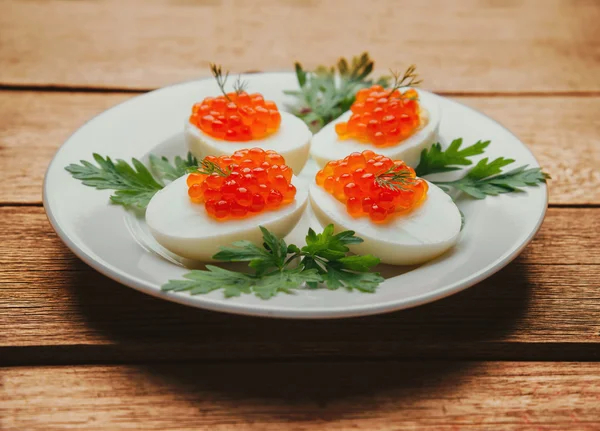 Boiled eggs half with red salmon caviar — ストック写真