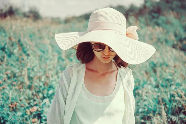 Mujer en gafas de sol y sombrero en el parque — Foto de Stock