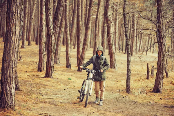 Wanita pejalan kaki dengan sepeda di hutan — Stok Foto