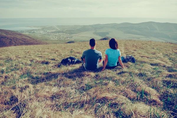 Pareja enamorada sentada en el prado de montaña — Foto de Stock