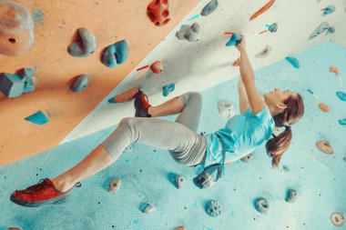 young woman training in climbing gym.