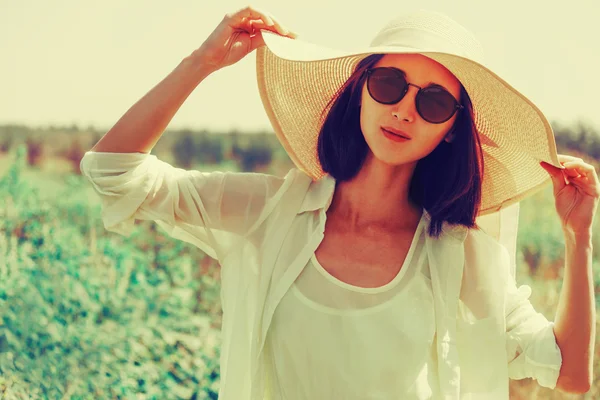 Femme en lunettes de soleil et chapeau — Photo