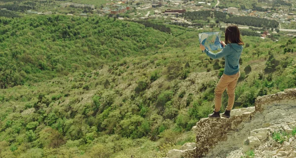 Kobieta stojąc z mapą w górach — Zdjęcie stockowe