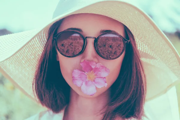 Mujer en gafas de sol y sombrero con flor —  Fotos de Stock