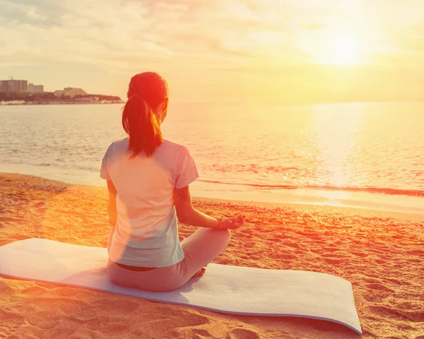 Woman meditating in pose of lotus at sunset — Stock Photo, Image