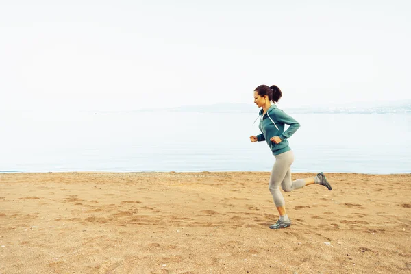 Sportieve vrouw lopen op zand strand — Stockfoto