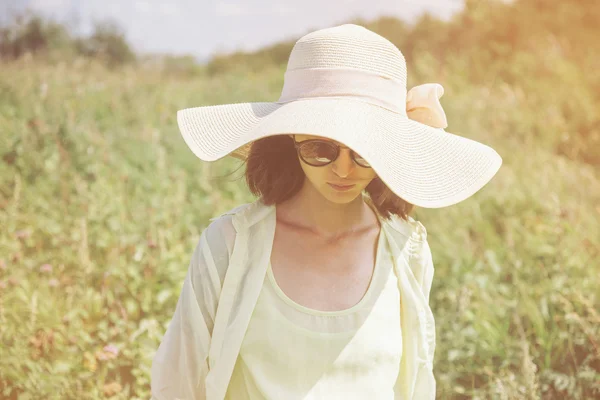 Femme en lunettes de soleil et chapeau reposant dans le parc . — Photo