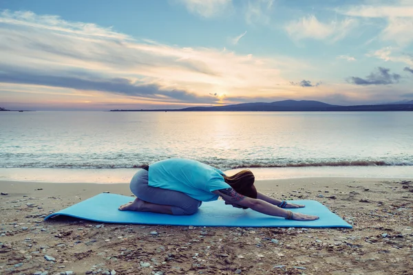 Kadın plajda yoga egzersizi yapıyor. — Stok fotoğraf