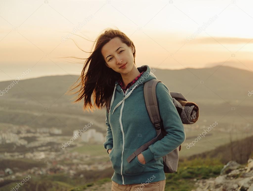 hiker woman with backpack on peak of mountain