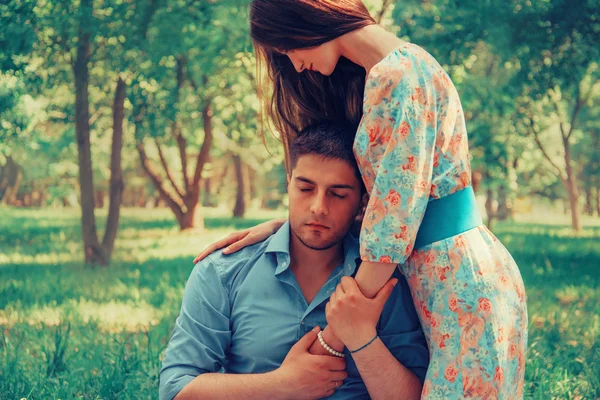 Женщина обнимает мужчину в летнем парке — стоковое фото