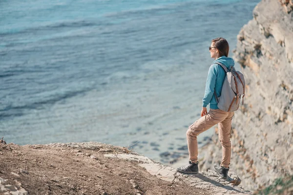 Mujer con mochila de pie en la costa — Foto de Stock