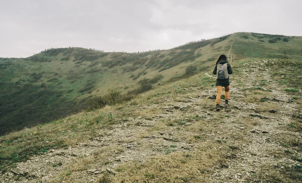 Caminhante mulher sobe na montanha — Fotografia de Stock