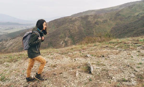 Женщина-туристка поднимается в горы — стоковое фото