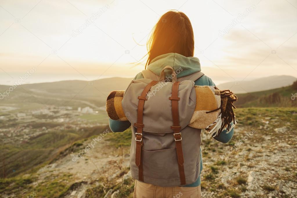 Hiker woman with backpack walking in mountains