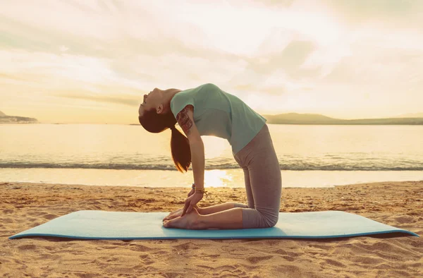 Frau macht Yoga-Übungen am Strand — Stockfoto