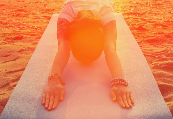 Vrouw doet yoga oefening op het strand — Stockfoto