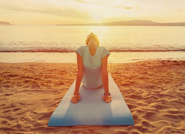 Young woman exercises on beach — Stock Photo, Image