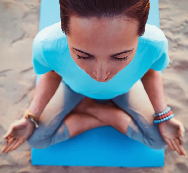 Mulher meditando em pose de lótus na praia — Fotografia de Stock