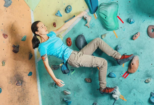 Kvinnan övningar på konstgjord boulder — Stockfoto