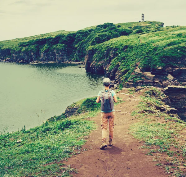 Escursionista donna con zaino a piedi sull'isola — Foto Stock