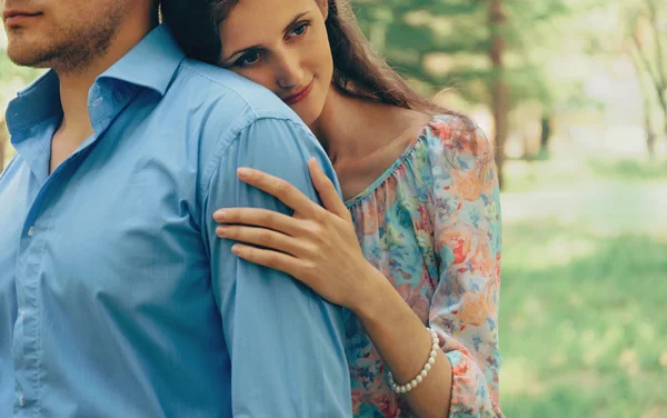 Woman embraces man in summer park — Stock Photo, Image