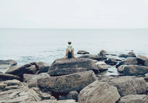 Chica excursionista descansando en la costa de piedra — Foto de Stock