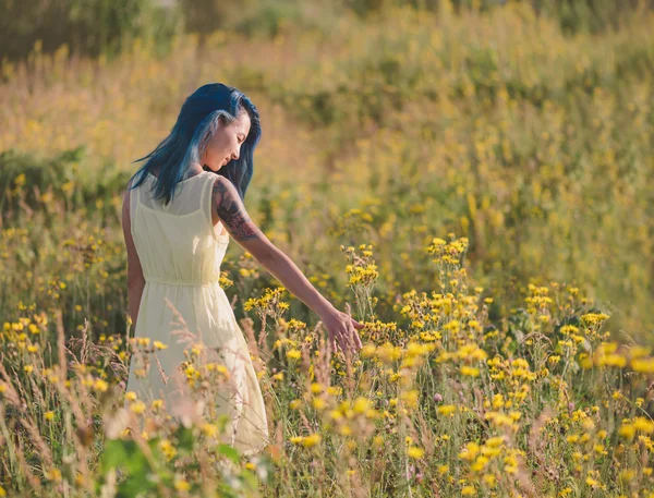 Bella ragazza che cammina sul campo di fiori — Foto Stock