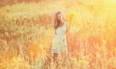 Güzel kız çiçek çayır üzerinde yürüyüş 