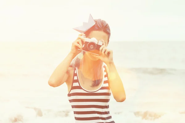 Beautiful girl takes a photograph on beach — Stock Photo, Image