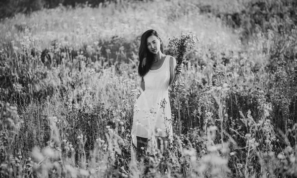 Bella ragazza che cammina sul prato di fiori — Foto Stock