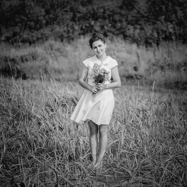 Belle jeune femme avec bouquet de fleurs — Photo